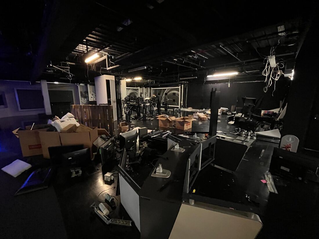 Studio floor mid-clearance with desks and monitors dismantled