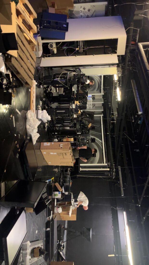 Engineers dismantling studio camera pedestals on set